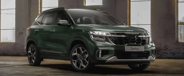 A bold, dark green Kia Seltos SUV parked indoors in a modern industrial setting.