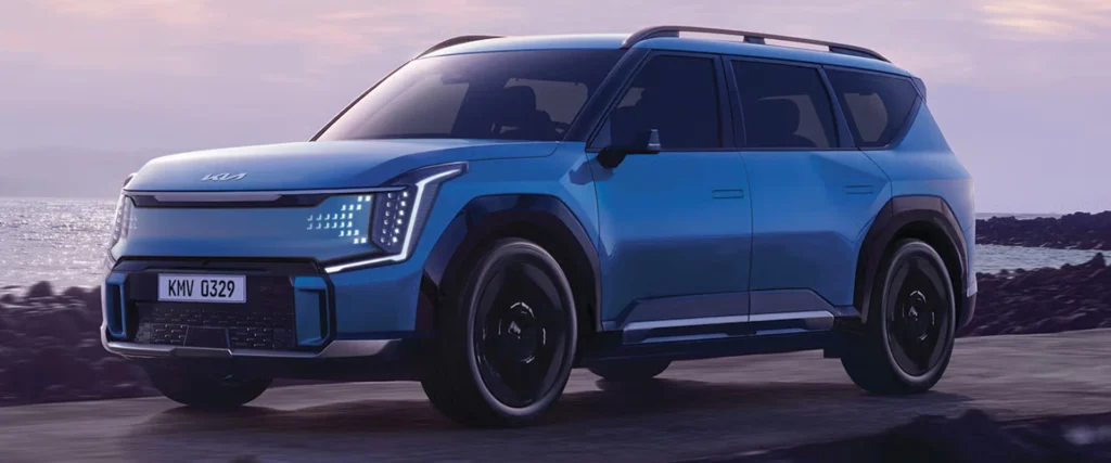 Blue Kia EV9 electric SUV on a coastal road